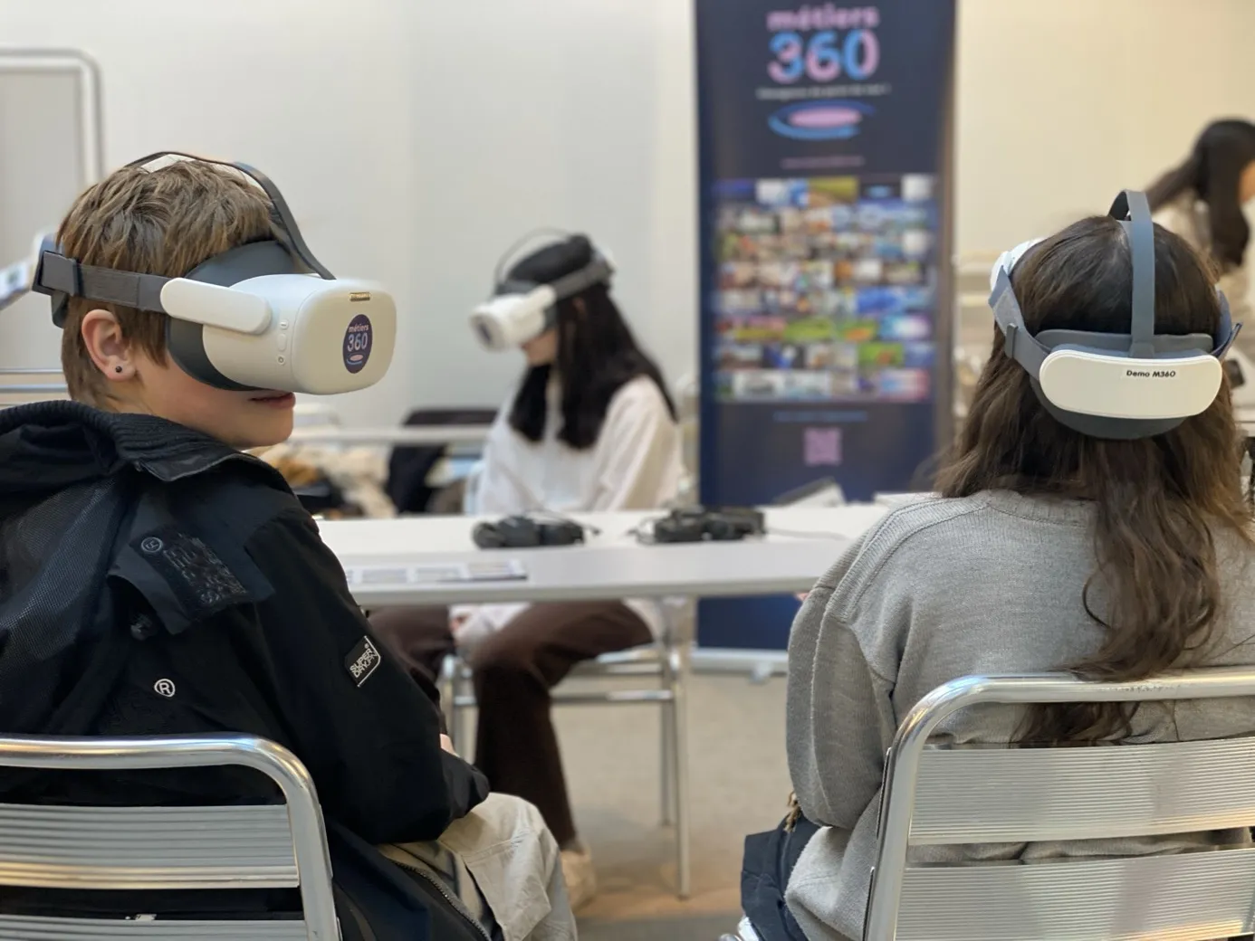 Trois jeunes casque de réalité virtuelle Métiers360 sur les yeux, assis lors d'une séance de découverte des métiers